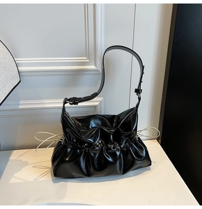 Détail du sac à bandoulière noir brillant plissé avec sangle réglable et cordon latéral