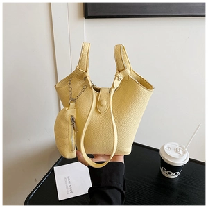 Detail of light yellow pebble leather bucket bag with matching pouch and top handle