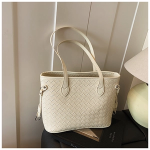 Detailed view of cream woven leather tote bag with silver hardware and shoulder straps