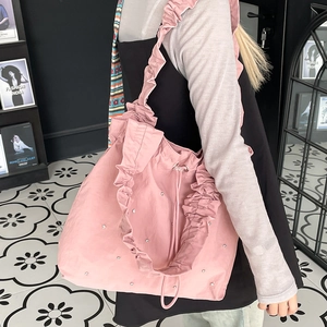 Pink pleated nylon tote bag with rhinestones shown on model in a cozy lifestyle setting