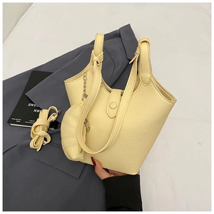 Detail of light yellow lychee pattern bucket bag with mini horn charm and strap
