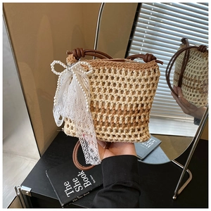 Détail du sac de plage en crochet avec nœud en perles et poignée ronde en cuir marron