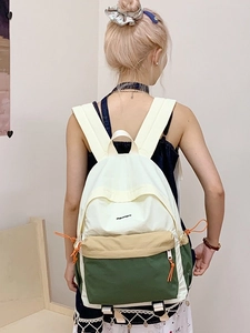 Color-block nylon backpack with drawstring details shown in a lifestyle model shot