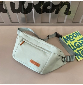 Détail d'un sac de poitrine en nylon vert menthe avec sangle réglable et écusson en cuir