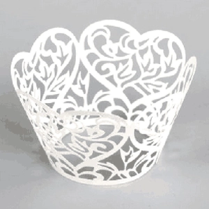 Macro view of white laser-cut cupcake wrapper with floral patterns and heart-shaped tops