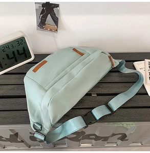 Détail du sac bandoulière en nylon vert menthe avec patch en cuir brun et sangle tissée