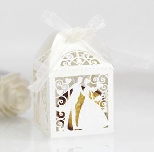 Laser-cut white wedding favor box with bride and groom silhouette and ribbon detail