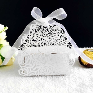 Detailed laser-cut rose pattern on white pearlescent paper favor box with ribbon