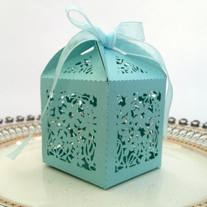 Detail of light blue laser-cut candy box with elegant ribbon bow for wedding gifts
