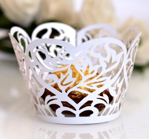Detailed laser-cut white cupcake wrapper featuring elegant vine and heart hollow patterns