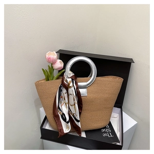 Detail of straw tote bag in gift box with silver ring handle and patterned scarf decor