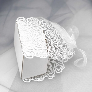 Detail of laser-cut rose pattern on white gift box with elegant organza ribbon