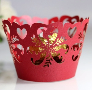 Detail showing red laser-cut cupcake wrapper with heart patterns and intricate snowflake lace