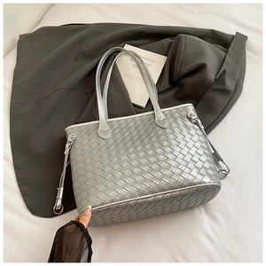 Detail of silver woven tote bag texture with side adjustment buckle and metal ring