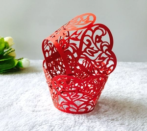 Detail view of red hollow heart lace cake wrappers with intricate laser-cut vine patterns