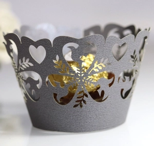 Detailed laser-cut silver cupcake wrapper with heart and bird patterns and a gold chocolate