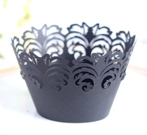 Elegant black laser-cut cupcake wrappers with intricate vine crown patterns for baking
