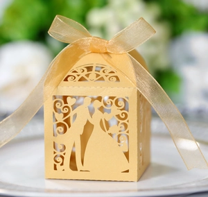 Detailed laser-cut gold wedding favor box with groom and bride silhouette and ribbon