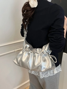 Sac nuage argenté plissé avec bandoulière en dentelle porté par un mannequin en bandoulière