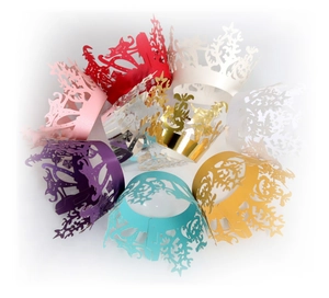 Close-up of laser-cut cupcake wrappers with snowflake and star patterns in multiple colors