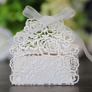 Laser cut white wedding favor box with rose patterns and an elegant silver ribbon bow