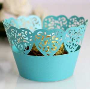 Detail of light blue laser-cut heart pattern cake wrappers with gold foil dessert inside