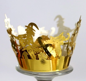 Macro detail of laser-cut Halloween cupcake wrapper with witch and castle motifs