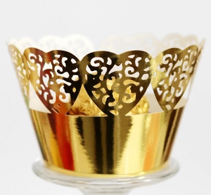 Macro detail of laser-cut gold heart cupcake wrappers with intricate vine pattern