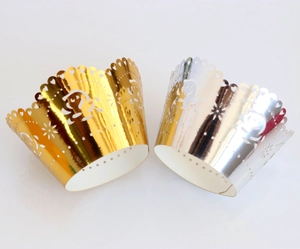 Detail of laser-cut heart pattern cupcake wrappers in metallic gold and silver finishes