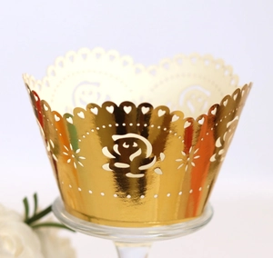 Detail showing the laser-cut rose patterns and mirror gold finish of cupcake wrappers