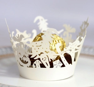 Detail of laser-cut Halloween cupcake wrapper with witch pumpkin and ghost patterns