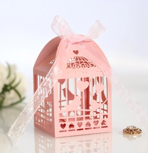 Vue détaillée d'une boîte à bonbons rose découpée au laser avec ruban d'organza et motifs cœur