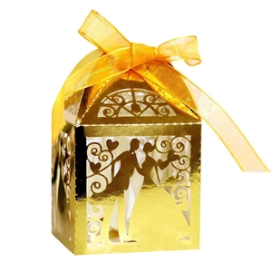 Macro detail of laser-cut gold wedding favor box with bride and groom silhouette