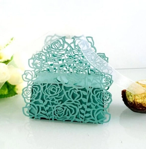 Detailed laser-cut rose hollow favor box with satin ribbon and chocolate sweets
