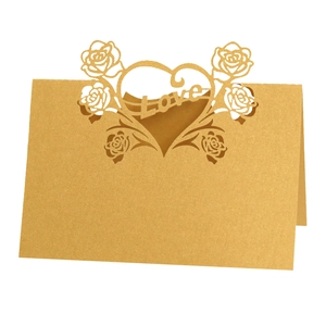 Detail of laser-cut gold pearlescent place card featuring Love and rose patterns