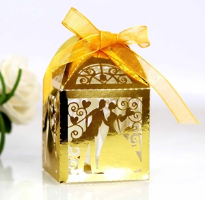 Detailed laser-cut pattern of golden wedding favor box with ribbon and bride silhouette