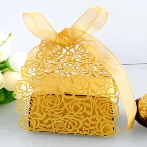 Detailed laser-cut gold wedding favor box featuring rose hollow design and ribbon bow