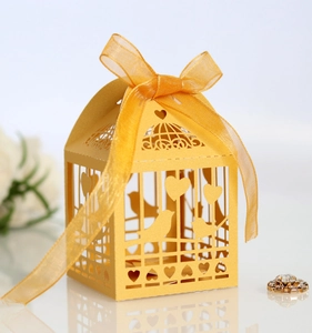 Détails de la boîte à bonbons jaune avec motifs d'oiseaux découpés au laser et cœur