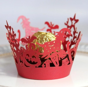 Macro shot of red laser-cut Halloween cupcake wrapper with witch and pumpkin patterns