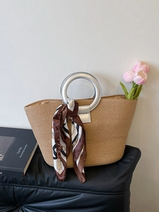 Fashionable woven straw tote bag with silver metal ring handles and printed silk scarf