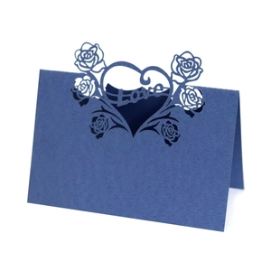 Detail of dark blue laser-cut heart and rose pattern on a standing wedding place card