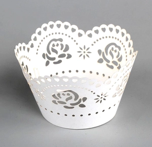 Close-up of white laser-cut cake wrapper with rose and heart lace hollow patterns