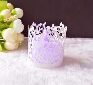 Dettaglio del paralume bianco tagliato al laser con foglie e luce LED viola soffusa