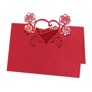 Detailed laser-cut heart and rose design on red wedding place cards with Love text
