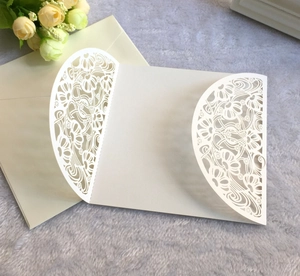 Detail der lasergeschnittenen weißen Hochzeitseinladung mit passendem Umschlag auf Plüsch