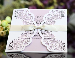 Détail de l'invitation de mariage découpée au laser avec motif floral et ruban en soie