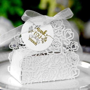 Close-up of white laser-cut rose gift box with Thank You tag and organza ribbon