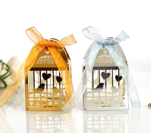Détail de boîtes à bonbons ajourées cœur en or et argent avec des rubans en organza