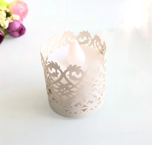 Macro shot of a cream-colored laser-cut paper candle sleeve with an LED light