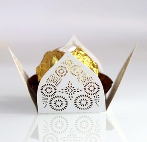 Macro shot of laser-cut white paper lace wrapper for chocolates with star patterns